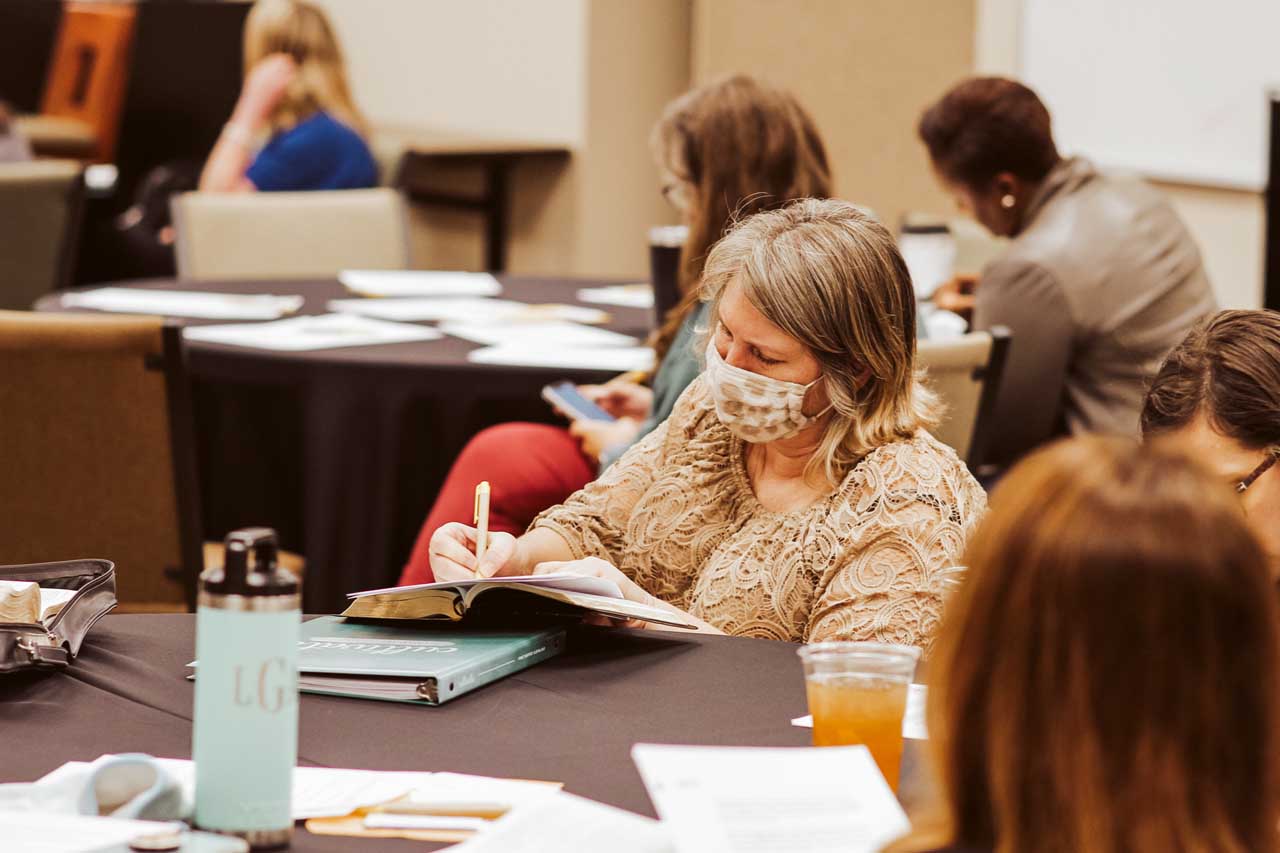 A woman takes notes during an adult group