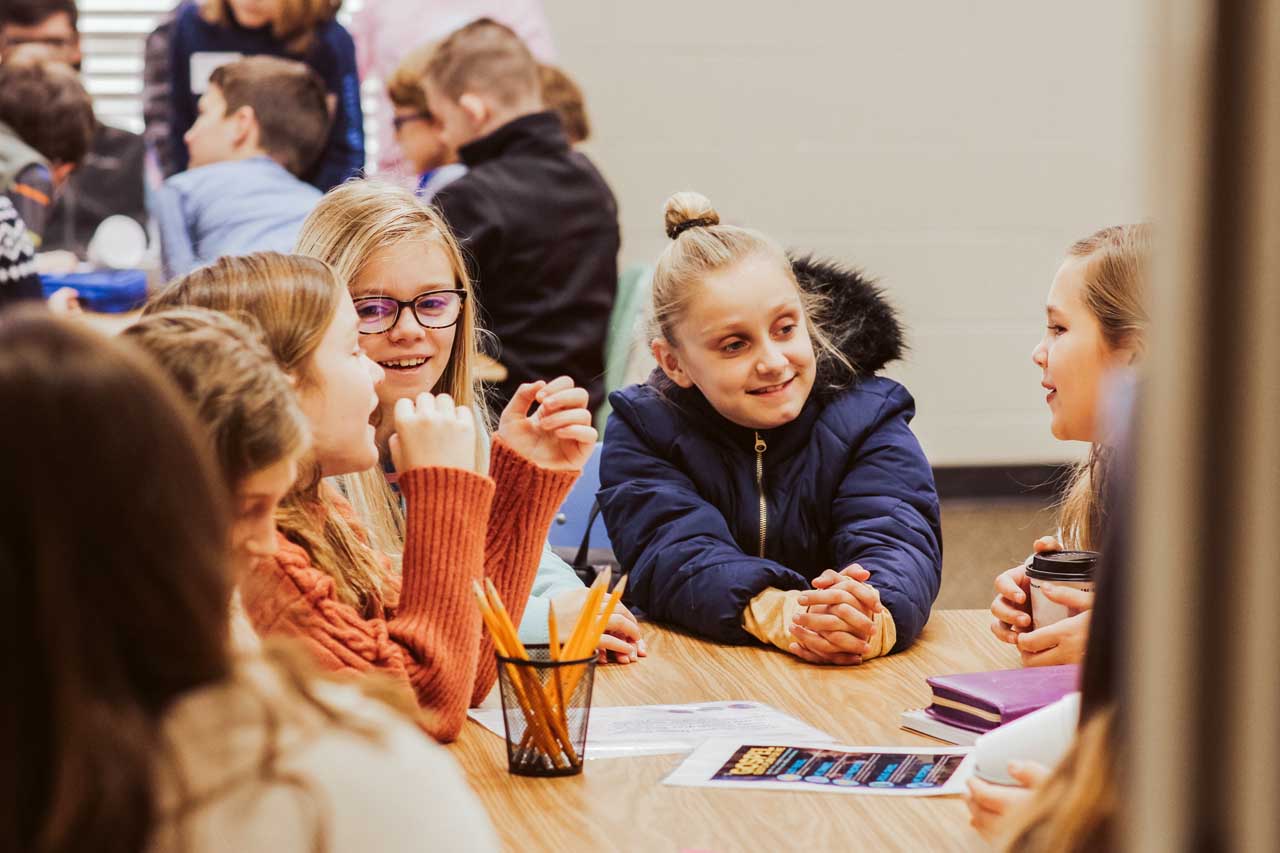 A group of young girls talk in a group